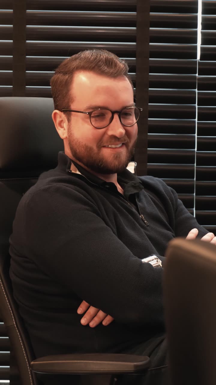 Alexandre Winkel sorrindo em conversa no escritório