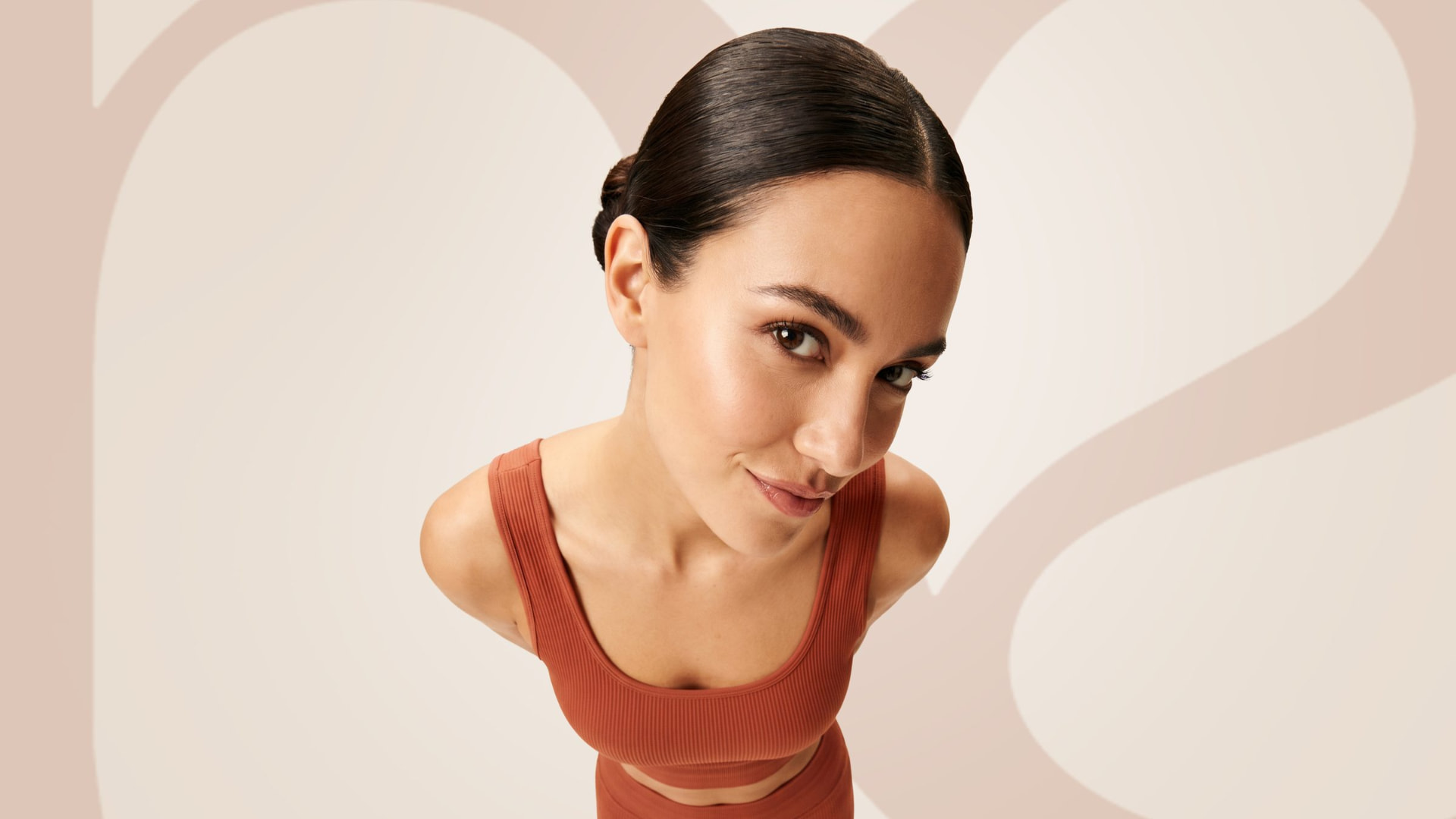 Campanha NEWELLA Activewear com modelo usando conjunto terracota
